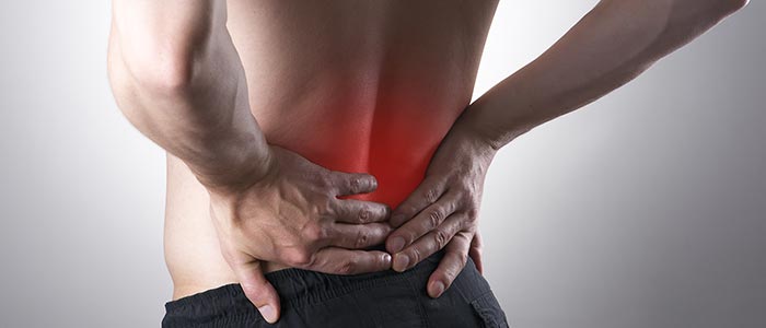 man holding his back in pain, the pain area is highlighted in red