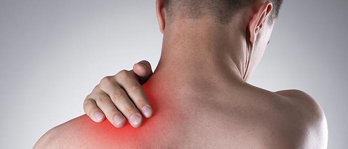 man holding his neck and back in pain