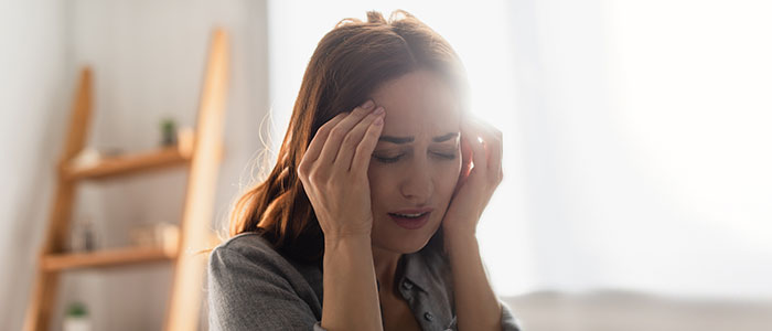 girl holding her head as if in pain